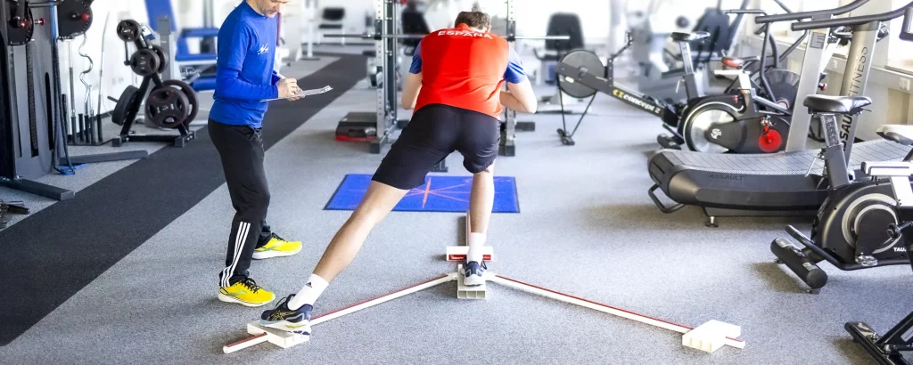Ein Therapeut testet die Y-Balance eines Patienten