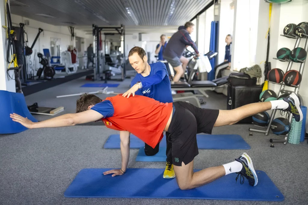 Ein Trainer und ein Klient bei einer gymnastischen Übung
